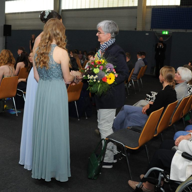 Jugendweiheteilnehmerinnen übergeben der Festrednerin ein Blumenstrauß